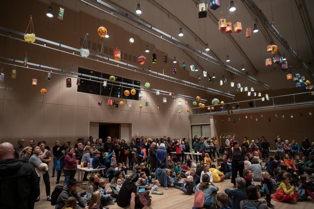 Über 200 Kinder und ihre Eltern warten auf das Lichterlöschen in der grossen Laternenausstellung während des Bauhaus-Laternenfests.