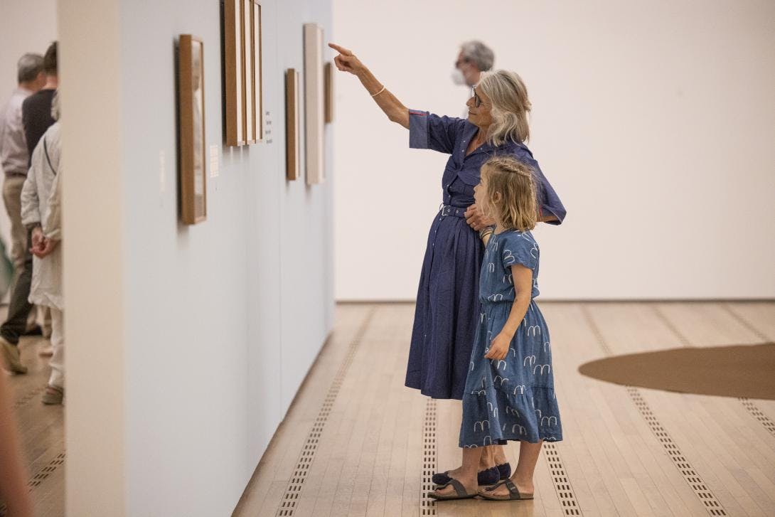Eine ältere Frau und ein Kind betrachten gemeinsam ein Werk von Paul Klee in der Ausstellung Kinder kuratieren Klee.