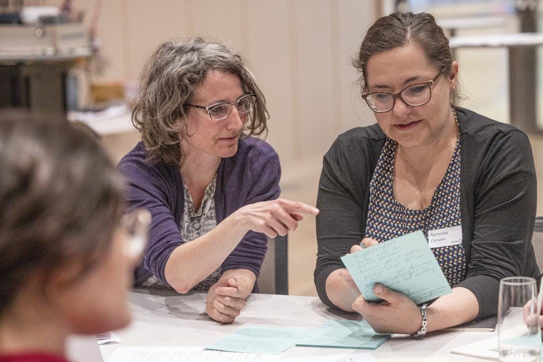 Zwei Teilnehmerinnen von Workshop P diskutieren über den Inhalt von einer der Thesen zu Partizipation im Museum.
