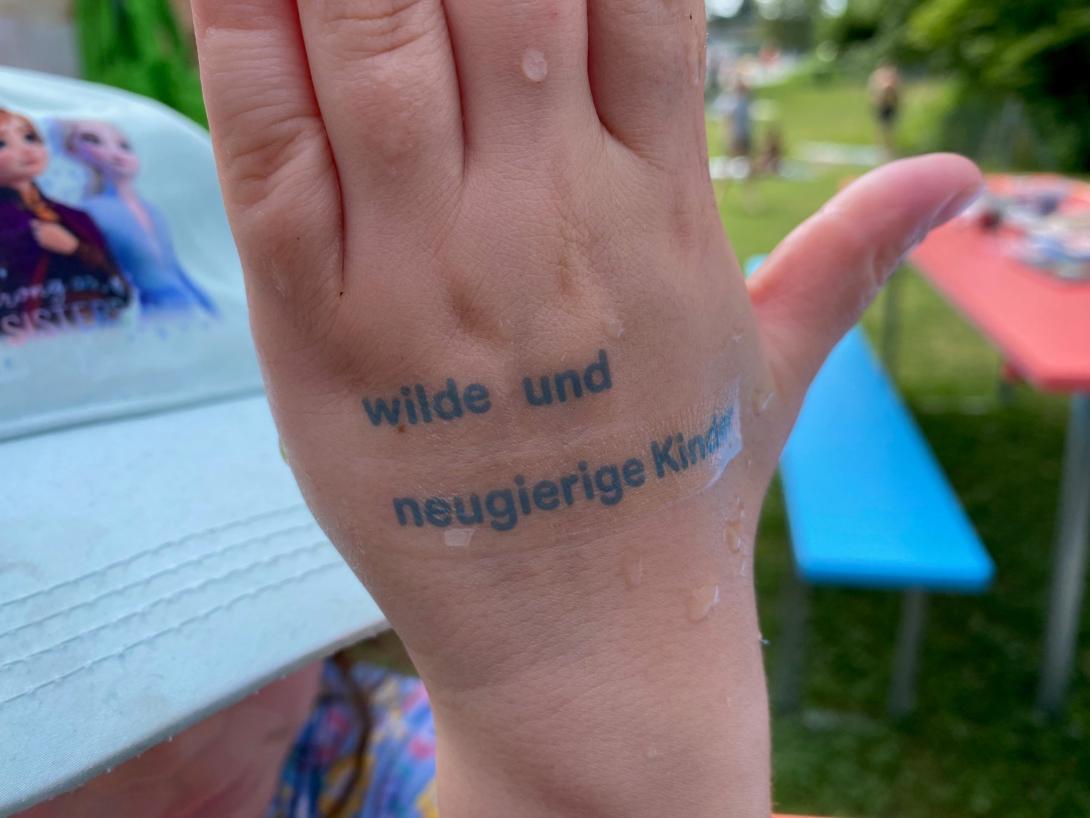 Kinderhand mit Klee-Tattoo "wilde und neugierige Kinder"