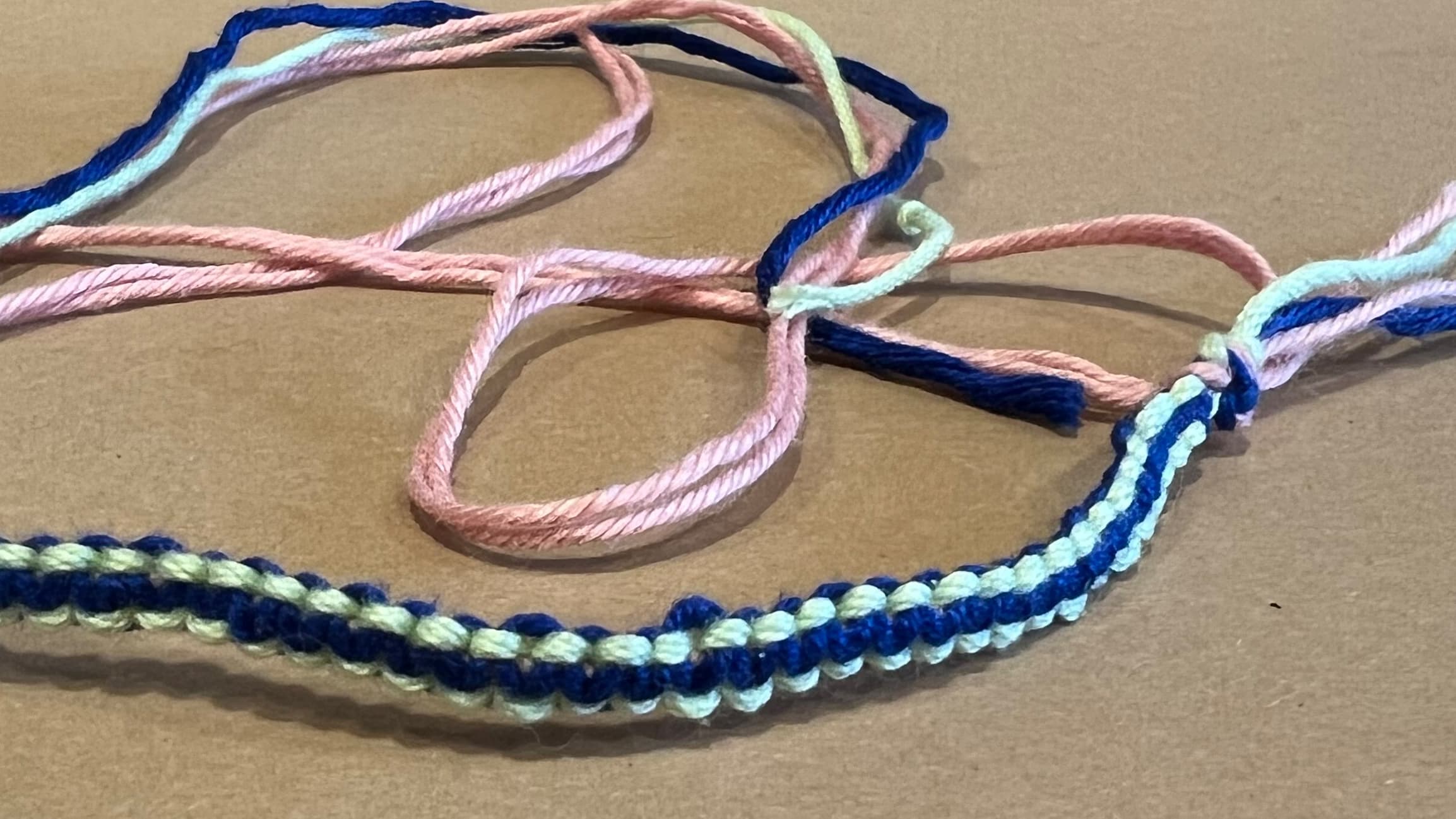 Ein geknüpftes Freundschaftsband in hell- und dunkelblau.